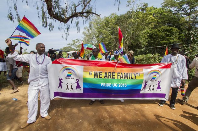 People hold a banner reading "We are Family" while waving rainbow flags as they take part in the Gay Pride parade in Entebbe on August 8, 2015. Ugandan activists gathered for a gay pride rally, celebrating one year since the overturning of a strict anti-homosexuality law but fearing more tough legislation may be on its way. Homosexuality remains illegal in Uganda, punishable by a jail sentence. AFP PHOTO/ ISAAC KASAMANI (Photo credit should read ISAAC KASAMANI/AFP/Getty Images)