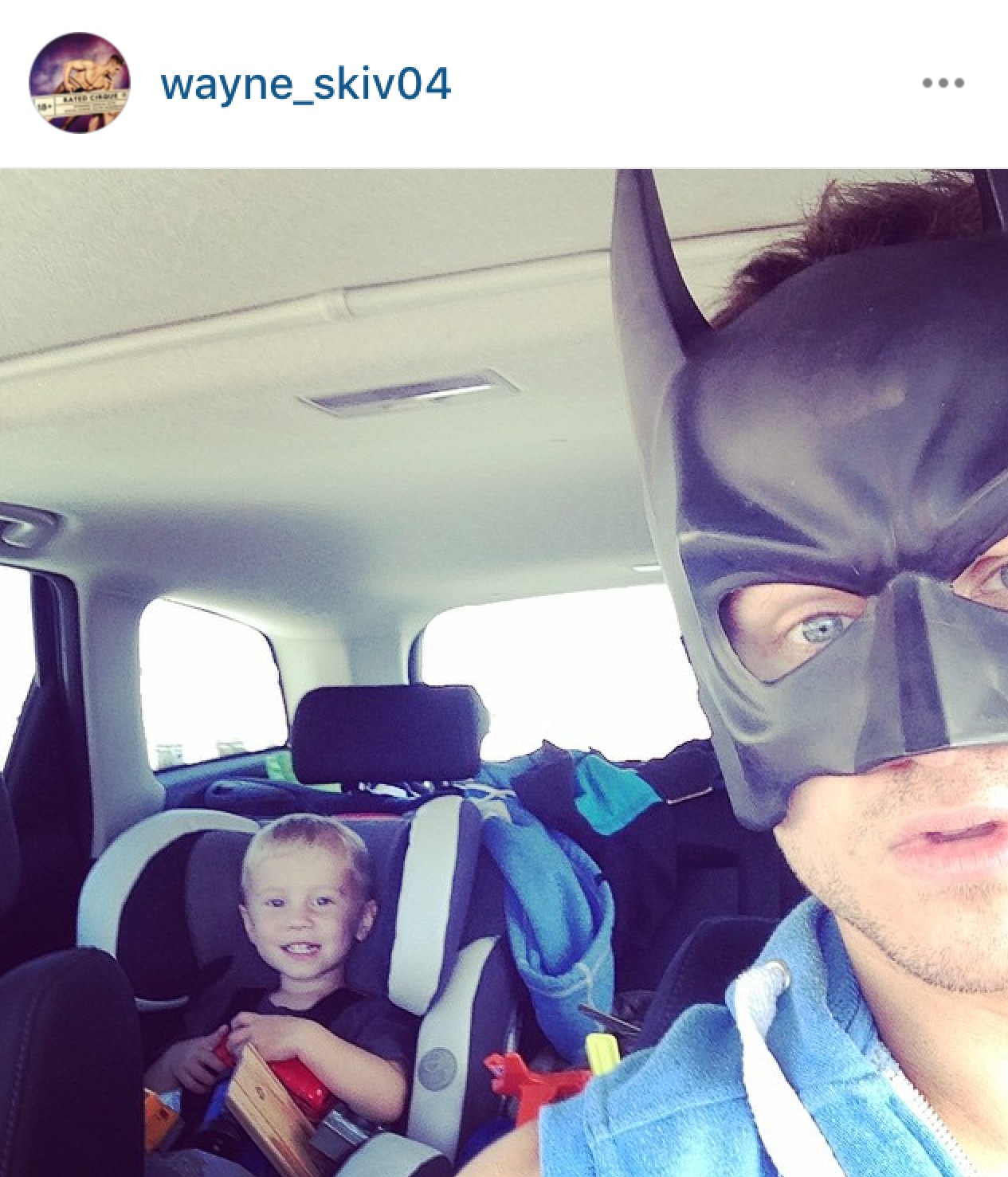 Super Dad Wayne Skivington wears batman mask with kid in car