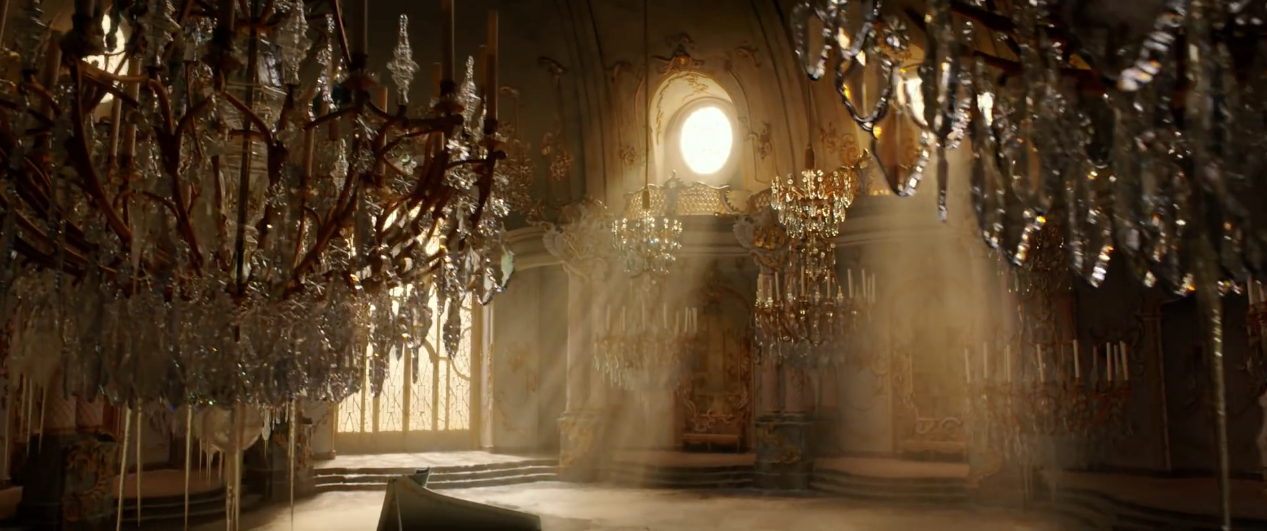 The gorgeous ballroom with chandeliers and grand piano bathed in golden light from the Beauty and the Beast live-action movie