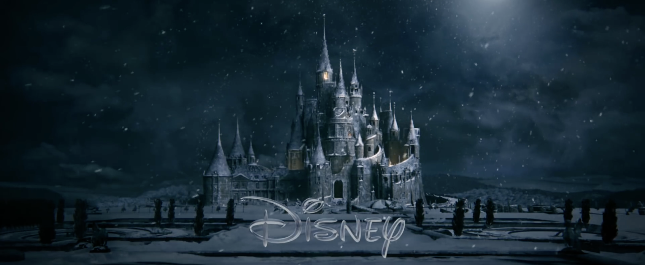 The Beauty and the Beast castle on a dark and snowy night with the disney logo in front of it 