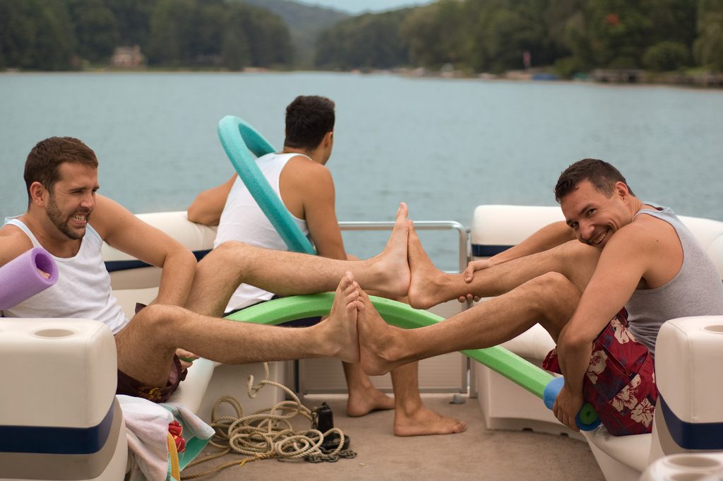 Three gay men on a boat in shorts overcoming some boundaries with long distance relationships