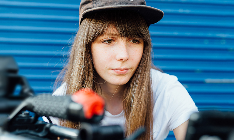 Kate Dolan with a cap and film camera is one of the LGBT people in Real Irish Jobs