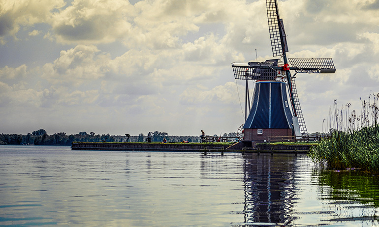 A windmill near a body of water in the Netherlands, which is one of the countries the lgbt Irish diaspora might relocate to