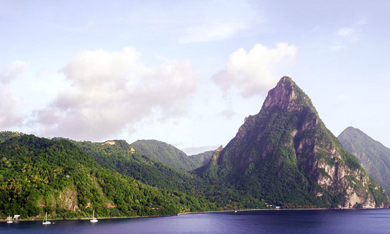A gorgeous mountain landscape photo with the sea at its base, one of the many locations that the LGBT friendly cruise ships run by Celebrity Cruises go to
