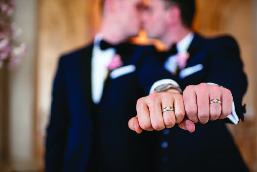 Thomas and Andrew's ring fingers in a fist showing off their rings from Andrew and Thomas' Real Weddings article