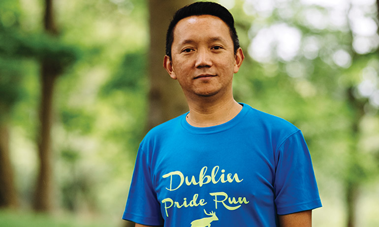 One of the Dublin Front Runners smiling and wearing a blue Dublin Pride Run T shirt