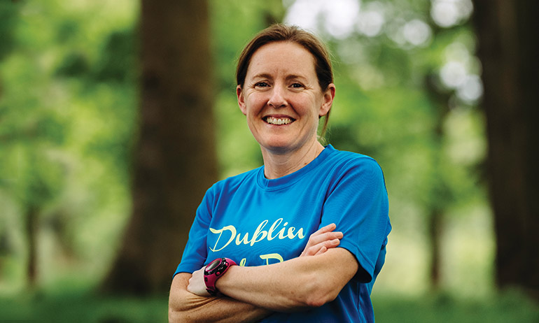 One of the Dublin Front Runners smiling and wearing a blue Dublin Pride Run T shirt