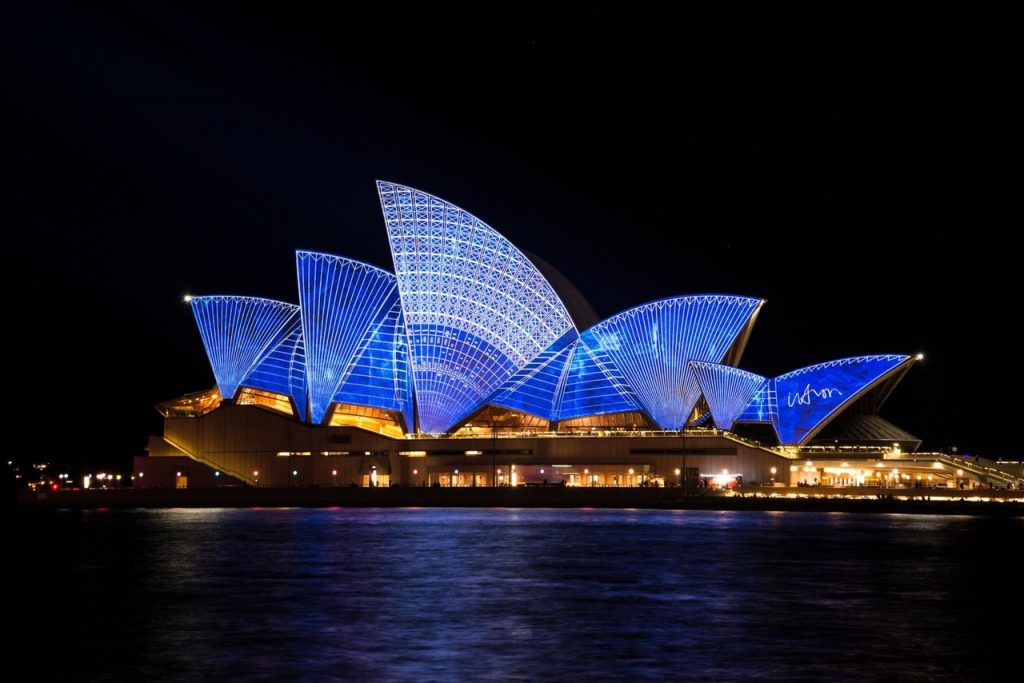 an image of sydney opera house at night illuminated in blue to indicate that an Irish diaspora vote from emmigrants in Australia might impact elections