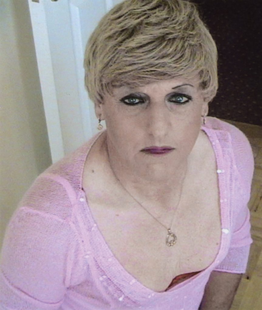 Christine Beynon from the art exhibition in Becoming Christine looking up with a pink blouse