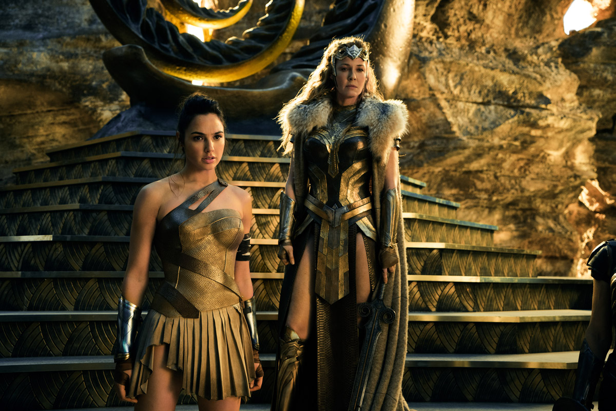 Wonder woman standing in golden clothes with another woman