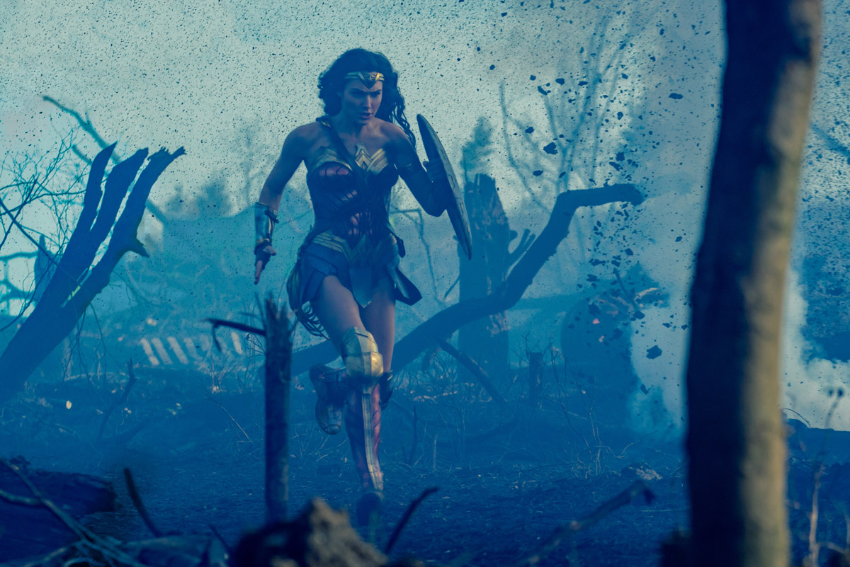 Wonder Woman running through a smokey battlefield