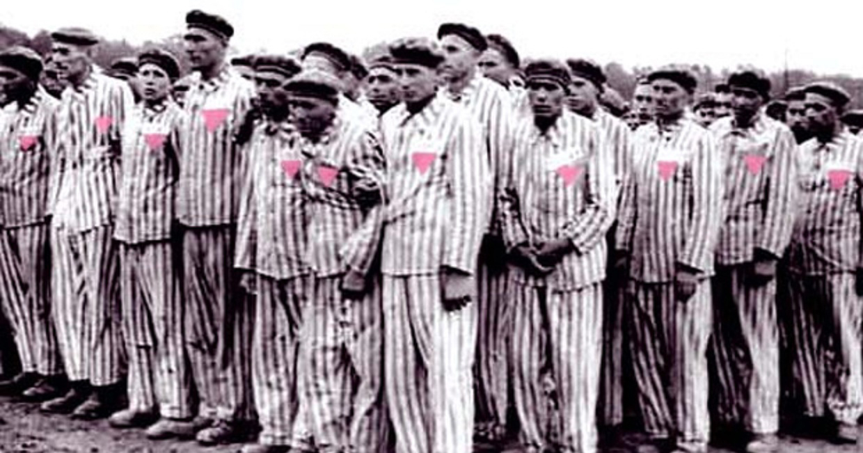 Men queuing in concentration camp wearing the pink triangle