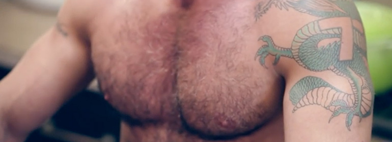 The bear-naked chef: hairy chest with a green dragon tattoo on his shoulder