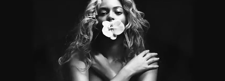 Beyonce with a flower in her mouth for her formation tour in black and white