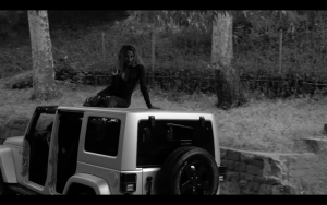 Trans Beyoncé Impersonator on top of a car in black and white