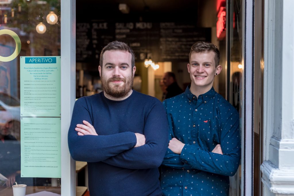Renan and Paul Keville sitting and standing outside Aperitivo