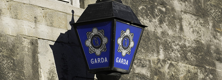 Garda - who have been reported to the garda ombudsman - logo symbol in a lamp on grey stone