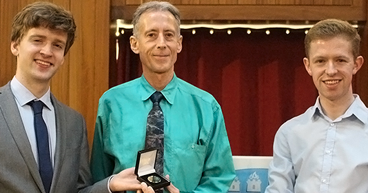 Peter Tatchell receiving the James Joyce Award at UCD with two other people.