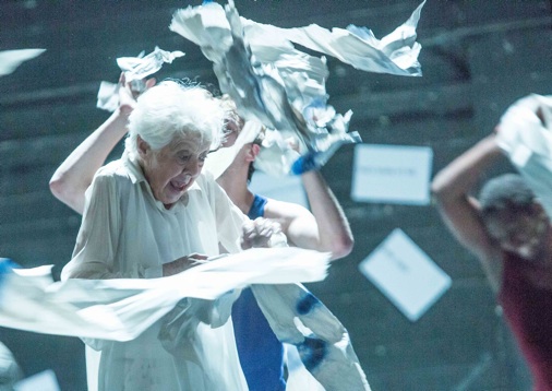 Lear in white with paper flying through the air