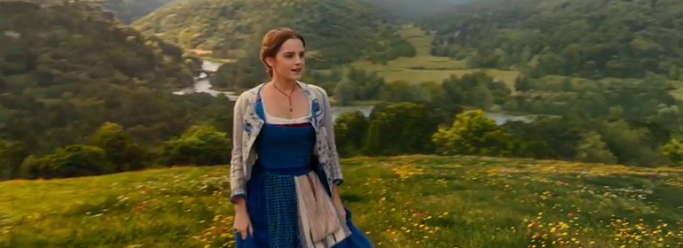 Emma watson as Belle in the new Beauty and the Beast trailer standing on a lush green mountainside in a blue and white dress, one of the stories in today's Cuppán Gay