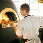 The wood burning oven with a chef taking a pizza out at sophie's restaurant at the dean hotel for the November 2016 Amuse Bouche