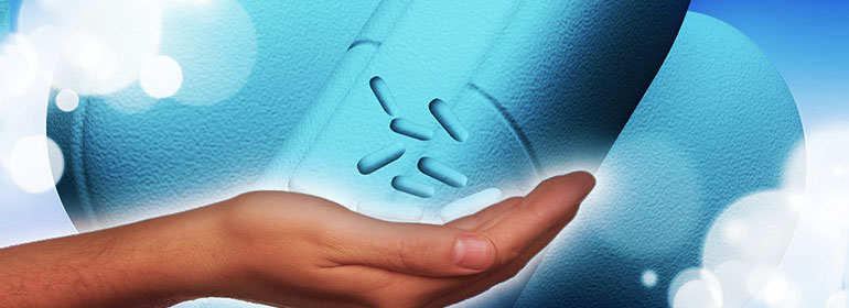 A person's hand with blue pills (like Truvada which will be available in the Discover Trial) floating upwards