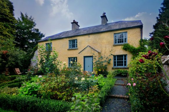 A yellow house with green plants in front of it at one of the Irish Landmark Trust venues - the same Irish Landmark Trust who has a Valentine's Giveaway
