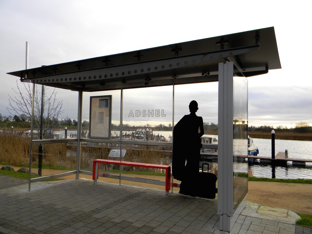 The silhouette of a woman with a suitcase at a bus shelter as part of Will St Leger's Out of the shadows art project