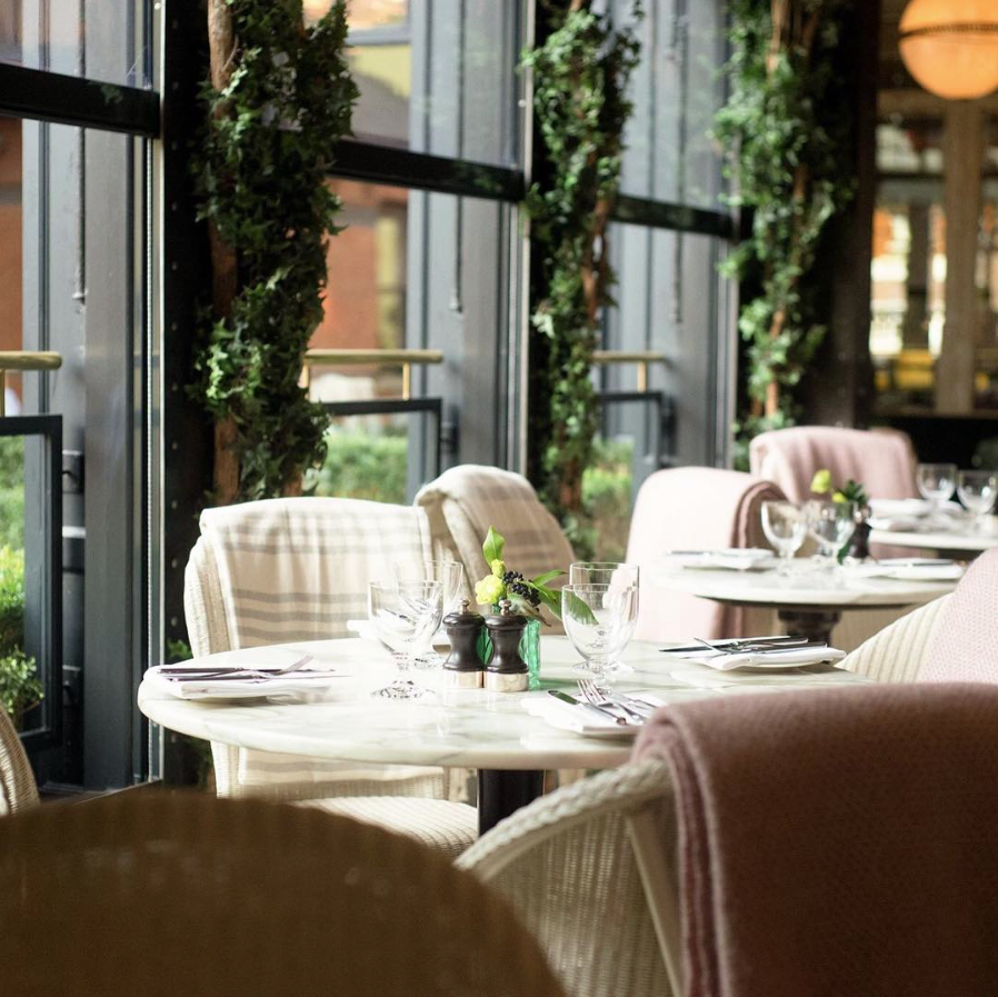 Tables with greenery behind them at Wilde restaurant, the place reviewed by James Kavanagh