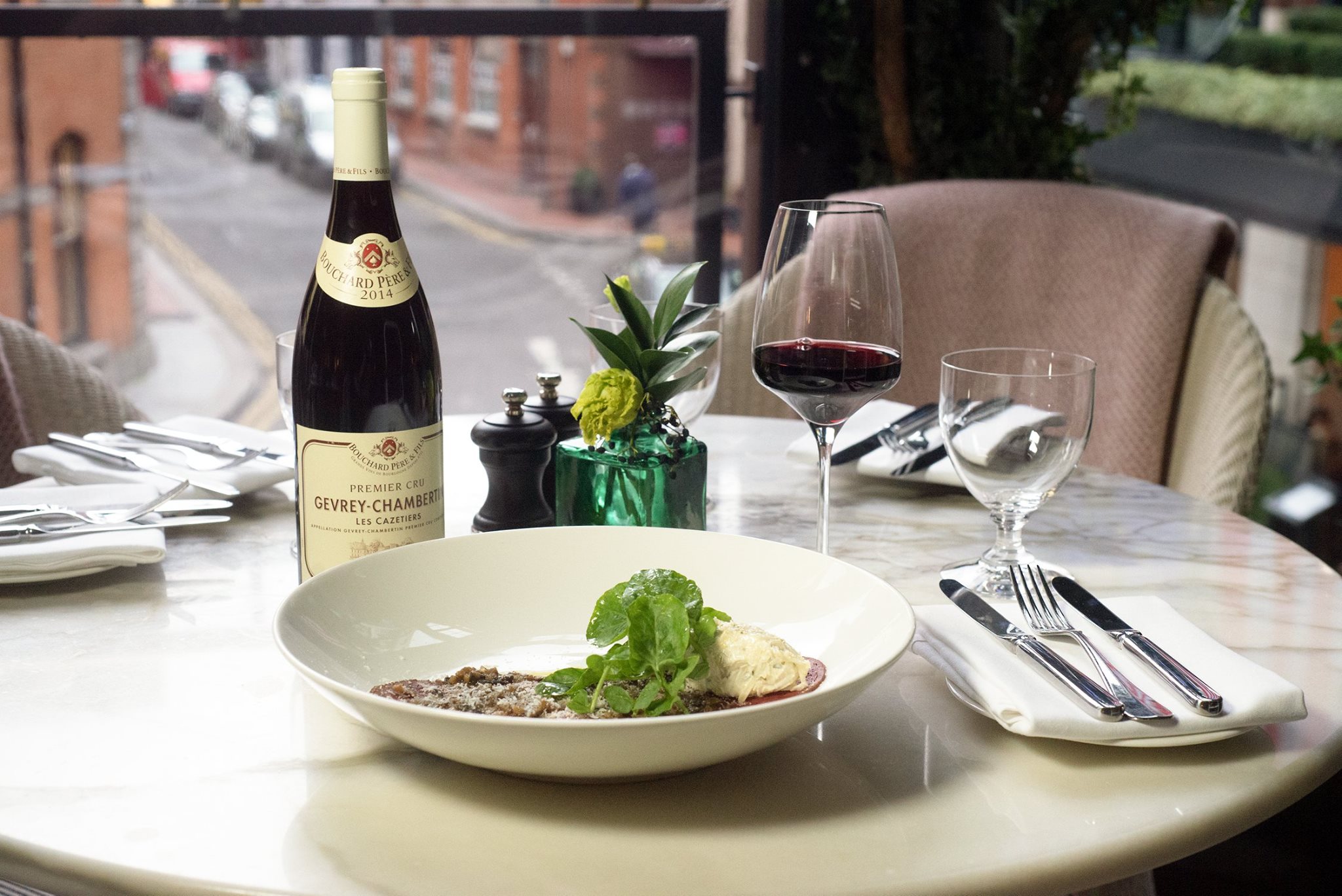 A bottle of wine and food on a table at Wilde restaurant, the place reviewed by James Kavanagh
