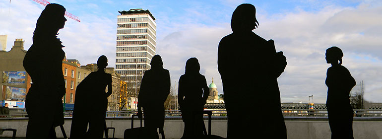 The silhouettes of women in Dublin with a suitcase as part of Will St Leger's Out of the shadows art project
