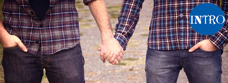 Two men holding hands in plaid shirts after winning the intro matchmaking membership competition