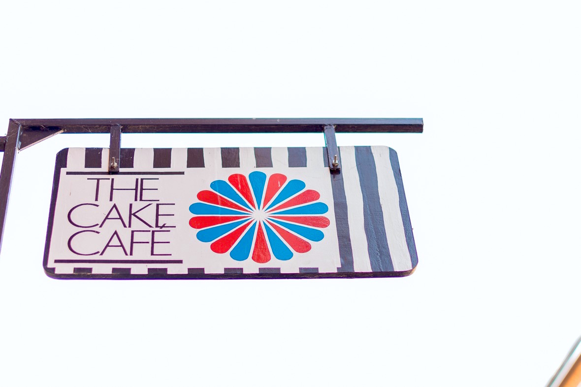 The Cake Cafe sign with a blue and red circle at the cake cafe and slice which are both owned by Ray O'Neill