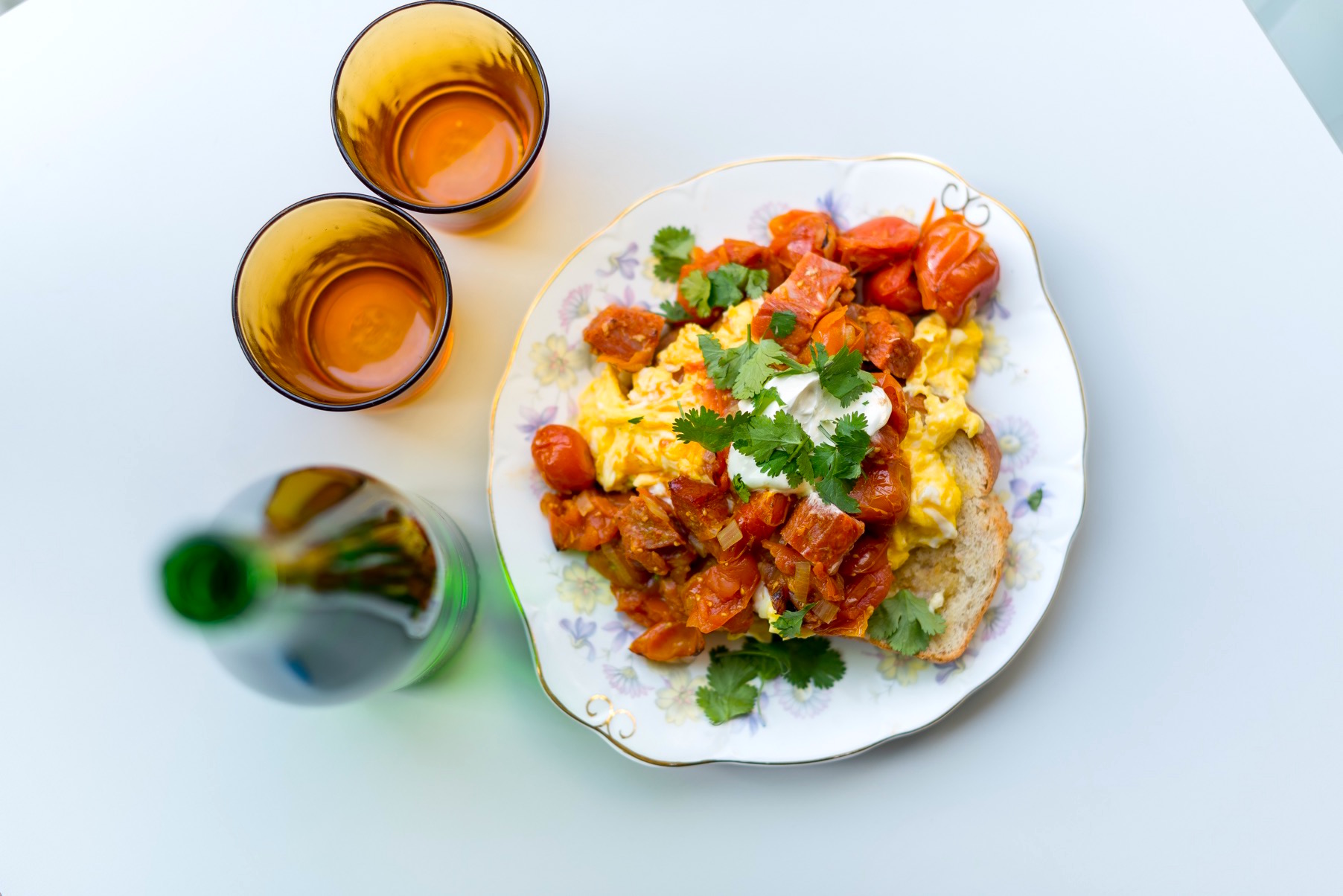 An overhead view of a bottle, two glasses and a plate of colourful food at the cake cafe and slice which are both owned by Ray O'Neill