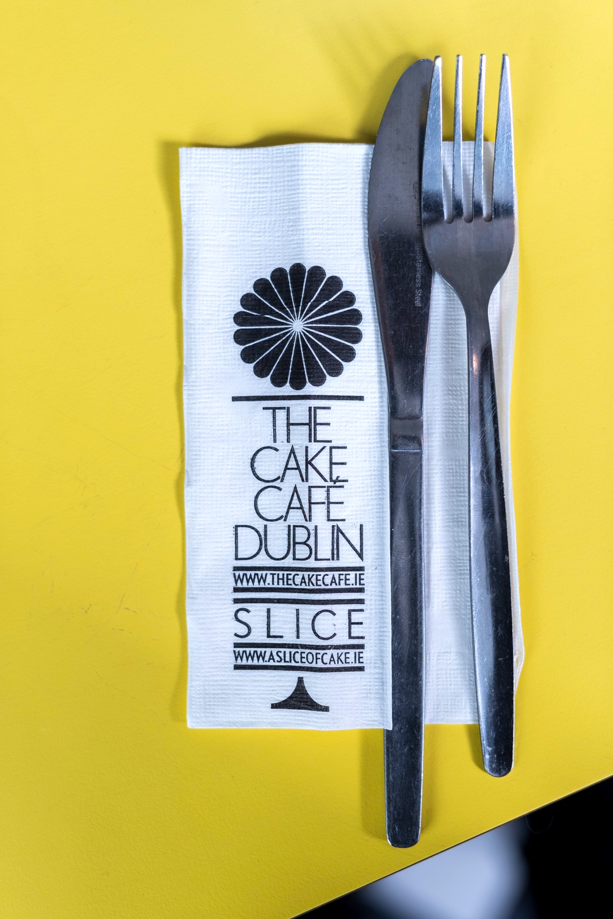 The Cake Cafe Dublin napkin with a knife and fork on it at the cake cafe and slice which are both owned by Ray O'Neill