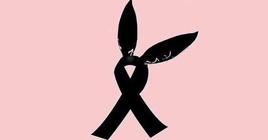 A pair of bunny ears from Ariana Grande's single 'Dangerous woman' atop a black ribbon on a pink background to represent those killed and injured at the Ariana Grande concert in Manchester Arena