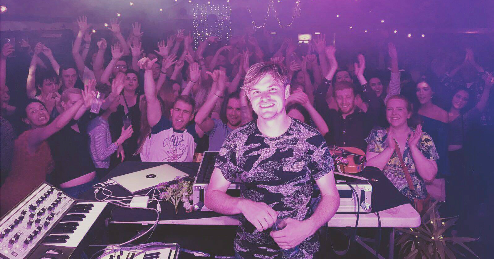 Dj Daithí stands in front of a crowd in a club