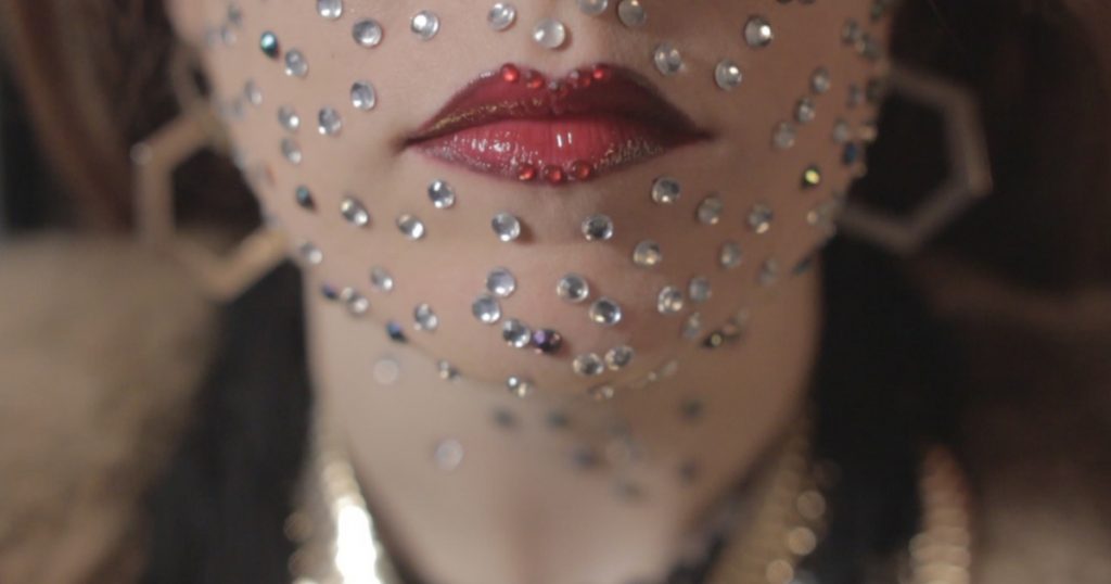 Close up of singer Sarah Byrne's lips, rhinestones on her face