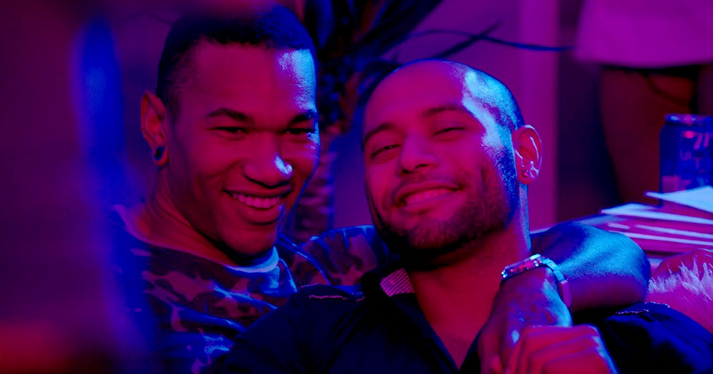 A gay couple smiling in red and blue light from the PrEP Project videos