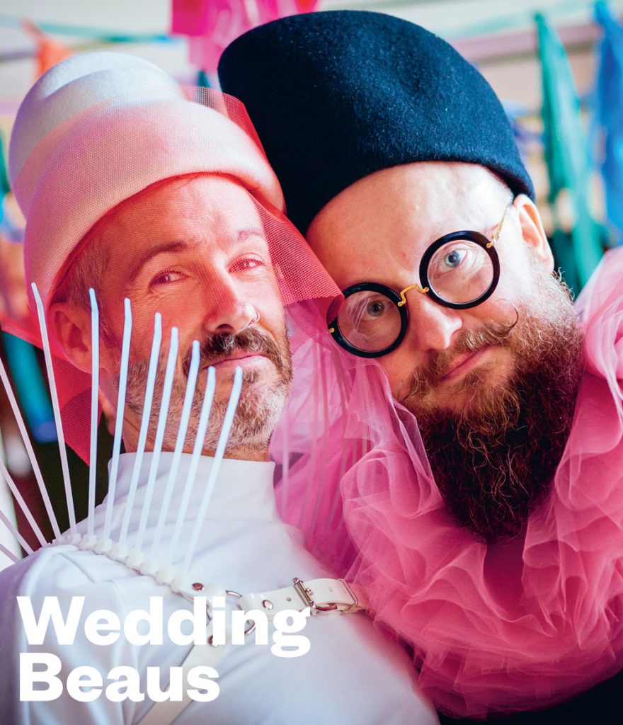 The two cover stars of the Wedding Beaus issue of GCN with a white leather spiky harness on one and round glasses and a hot pink ruffle collar