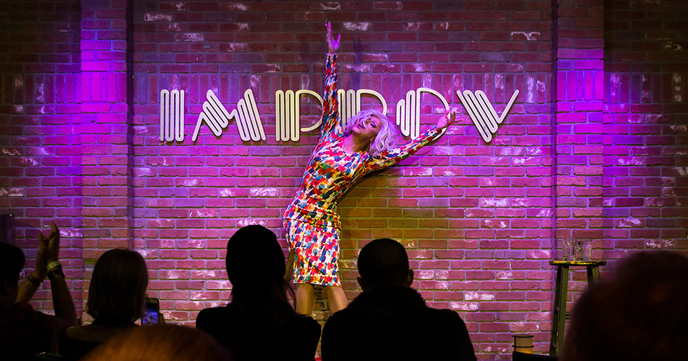 Panti doing a stretch on stage at the Hollywood Improv