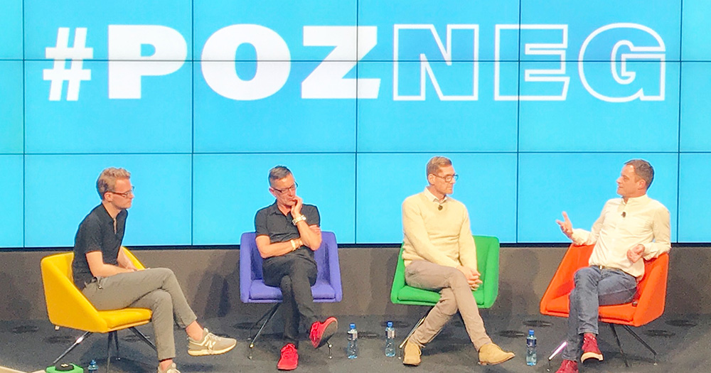 The panellists sitting on colorful chairs at the Pozneg event with screens behind them