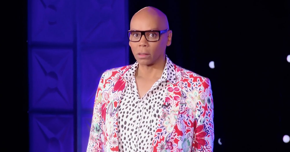 RuPaul standing in a bright white and red suit to promote RuPaul's Drag Race All Stars 3