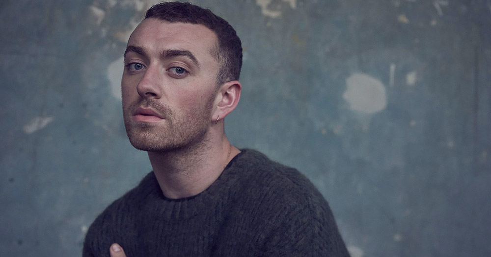 Sam smith standing in front of a splotchy wall