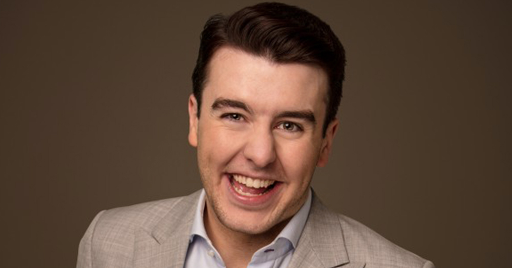 Al Porter smiling in a beige suit against a brown background, the same comedian against which claims of sexual misconduct have emerged