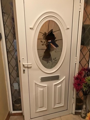 A photo of Franci Timmons front door. The glass in the center has been smashed in. The letterbox has been sealed up, most likely in an attempt to prevent hate mail.