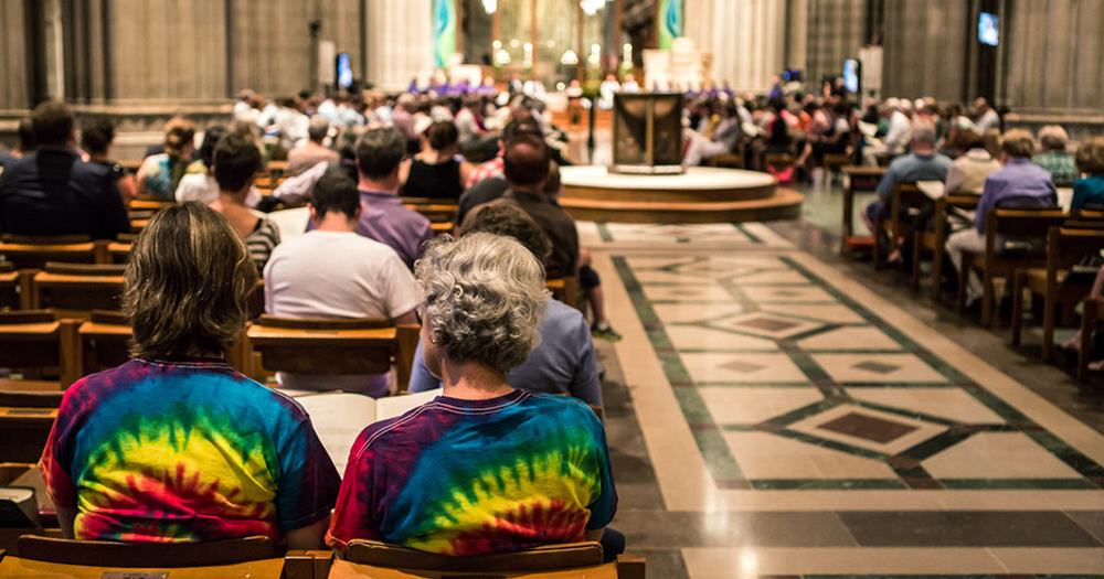 Couple sit in a church wearing tie dye t-shirts