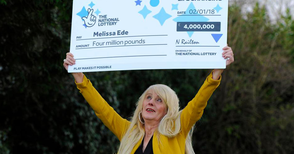 Milissa joyfully holds oversized cheque for £4 million in the air