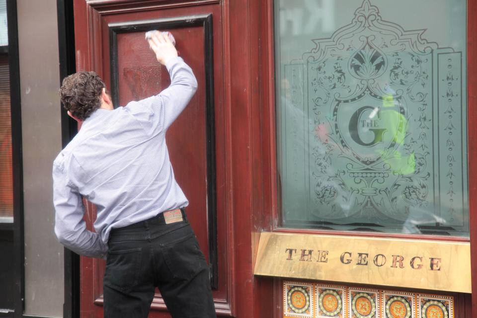 A man cleans the facade of the George