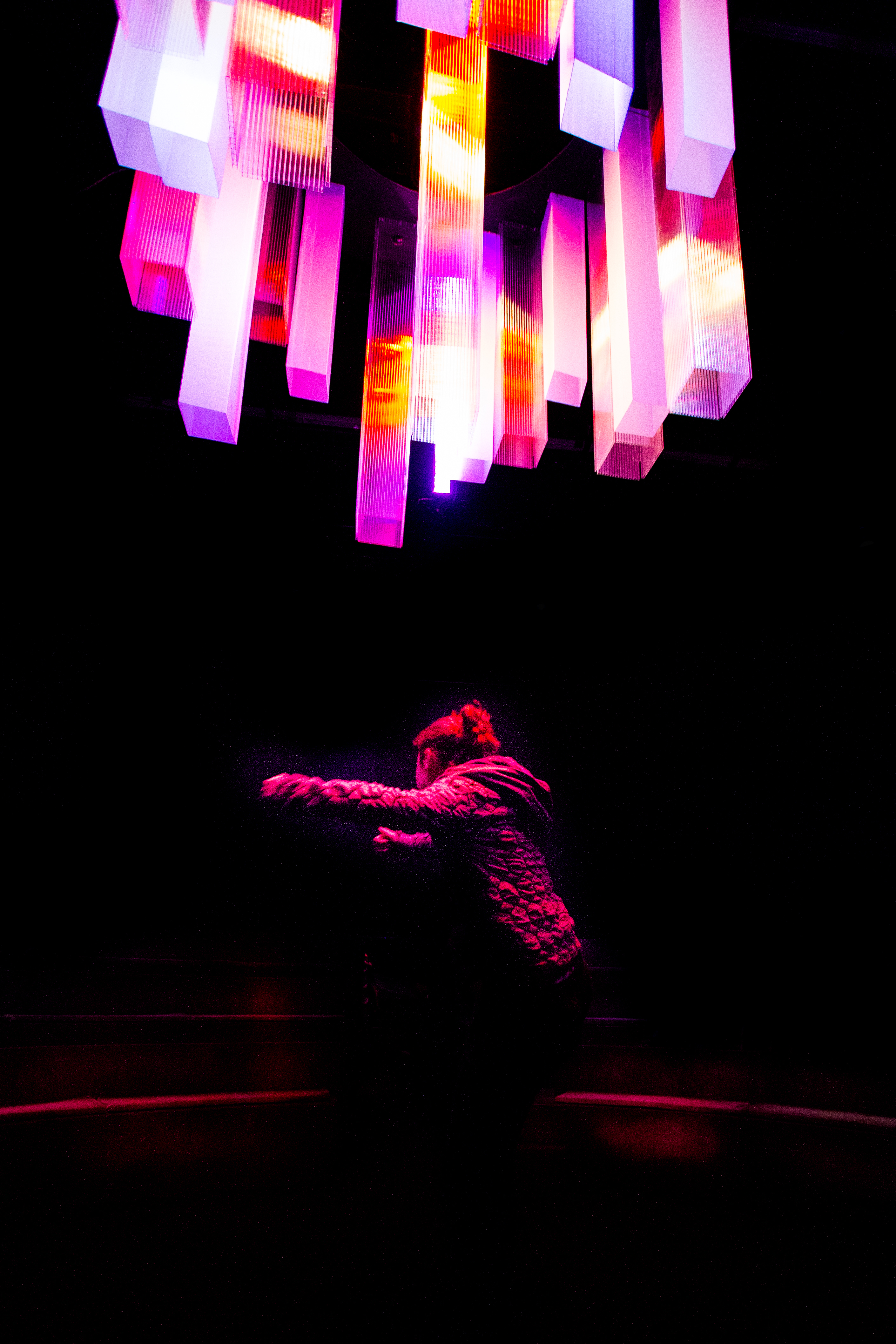 Scorch Kes sits under a giant pink light